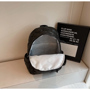 Detailed interior view of black quilted puffer backpack with spacious main compartment