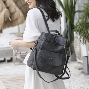 Detail shot of a black vintage PU leather backpack featuring metal buckle and multi-pockets