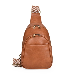 Detail of vintage brown PU leather crossbody bag with bohemian style woven strap