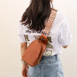 Brown vintage PU leather chest bag with ethnic geometric woven strap shown on a model
