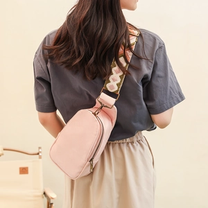Pink PU leather crossbody bag featuring a vintage woven geometric wide shoulder strap