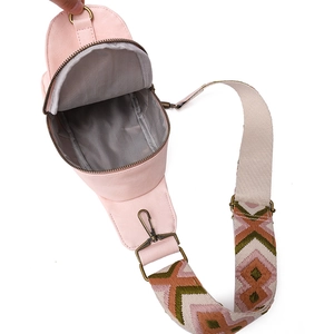 Close-up of pink PU leather chest bag featuring ethnic woven strap and spacious interior
