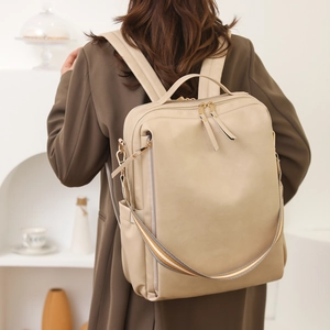 Rear view of an apricot minimalist PU leather laptop backpack on a model's back