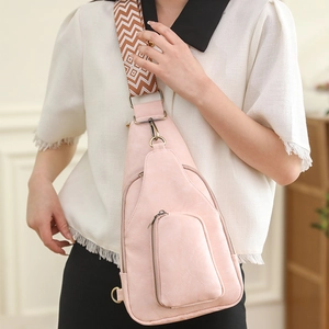 Detail of pink PU leather chest bag with a geometric woven strap and vintage zippers