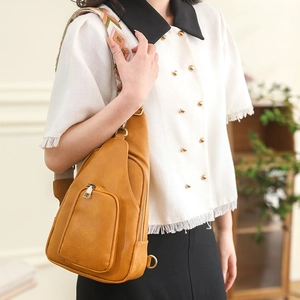 Close-up of mustard yellow PU leather sling bag with geometric woven shoulder strap