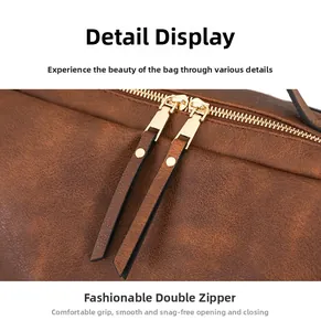 Detail of vintage brown PU leather bag featuring dual gold metal zippers and long pulls