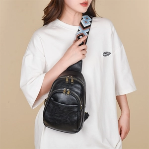 Detail of black PU leather chest bag with a colorful geometric jacquard woven strap
