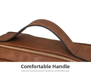 Detail of comfortable brown leather handle with reinforced stitching and gold zipper