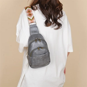 Detail of retro gray PU chest bag with ethnic pattern wide strap on a female model