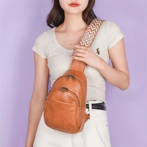 Detail of vintage brown PU leather sling bag with bohemian patterned wide shoulder strap