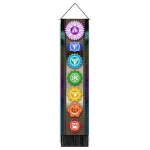 Close-up of bohemian yoga wall tapestry featuring seven colorful chakra symbols and black tassels