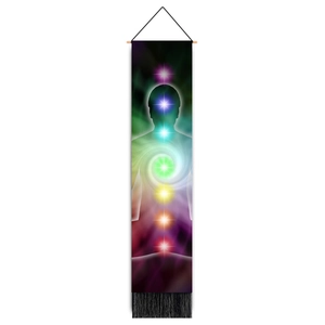 Detail of bohemian chakra wall hanging with wooden rod and black tassels on white backdrop