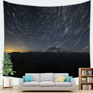 Detail view of starry star trail galaxy tapestry hanging above a modern living room sofa