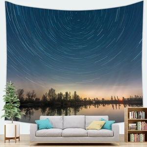 Detail of starry night galaxy tapestry with star trails and calm lake reflection