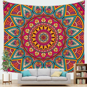Detail van een levendig mandala wandtapijt achter een bank in een boho woonkamer