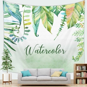 Detail of a watercolor tropical palm leaf tapestry hanging on a white living room wall