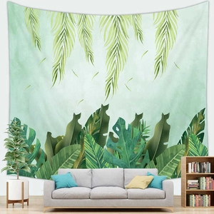 Detail of tropical palm and monstera leaf tapestry wall hanging above a modern sofa