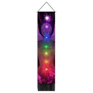 Close-up of a chakra wall hanging with wood rod, purple gradient fabric, and black tassels