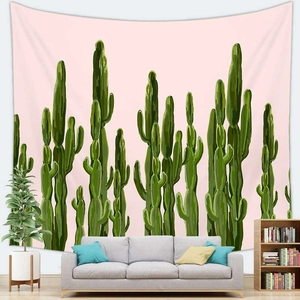 Detail of pink tapestry with green cactus print hung over a modern sofa in a living room