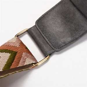 Detail of grey suede strap with vintage brass ring and woven herringbone pattern