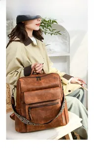 Vintage brown leather backpack with multiple pockets and embroidered ethnic shoulder strap