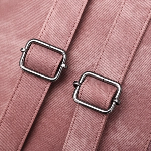 Detailed macro view of pink backpack straps with grey metal adjustment buckles