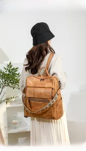 Detail view of brown vintage backpack with floral embroidered strap and multiple pockets