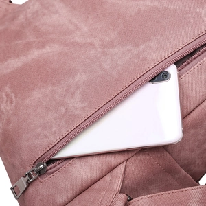 Detail of dusty rose backpack featuring smooth metal zipper pocket with a smartphone