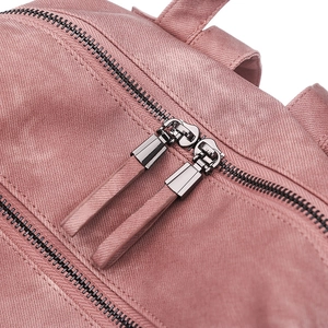 Detail of pink backpack showing durable fabric texture and dual metal zippers
