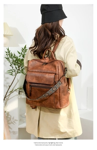 Brown leather backpack for women featuring an ethnic embroidered floral wide strap