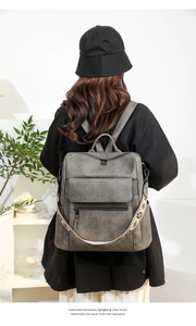 Detail of grey urban backpack featuring a wide bohemian style embroidered shoulder strap