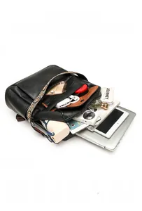 Black pebbled leather backpack showing interior capacity with 14-inch laptop and essentials