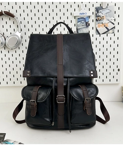 Détail du sac à dos vintage en cuir noir avec sangles brunes et boucles en métal