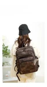 Detail of vintage brown leather backpack with multiple zipper pockets and textured fabric