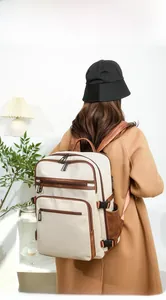 Business laptop backpack with ivory fabric and brown leather details shown on model