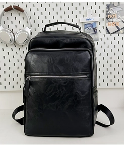 Close-up of black retro PU leather backpack with multiple zip pockets and top handle