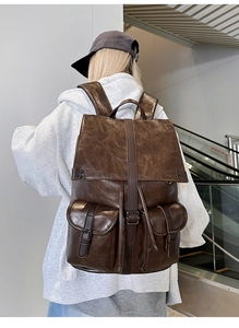 Détail d'un sac à dos vintage en cuir PU marron foncé avec poches à boucle et métal antique