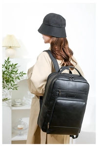 Detailed side view of a large black leather business backpack on male model