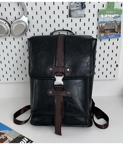 Close-up of black PU leather backpack with silver buckle and brown contrast straps