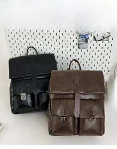 Dettaglio di zaini vintage in pelle PU con fibbie metalliche in nero e caffè scuro