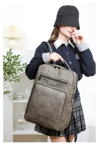 Detailed view of dark grey PU leather business backpack with front dual zipper pockets