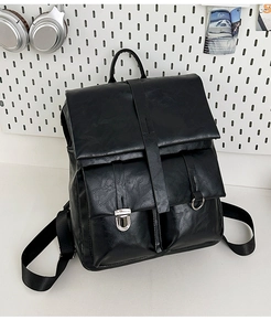 Dettaglio dello zaino in pelle PU nera con fibbie in argento su pannello bianco