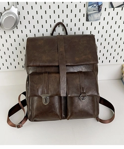 Dettaglio dello zaino vintage in pelle PU marrone scuro con tasche a fibbia e texture