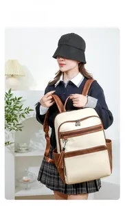 Close-up of contrast leather backpack with functional zipper pockets and tassel charm