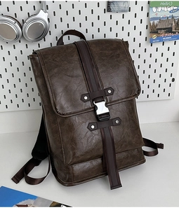 Detail of vintage brown leather backpack with silver buckle on creative pegboard background