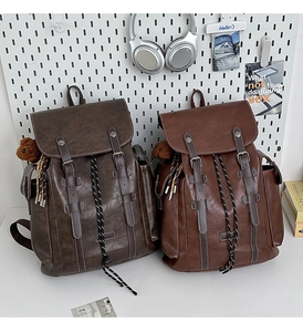 Close-up of retro brown PU leather backpacks with drawstring closure and bear charms