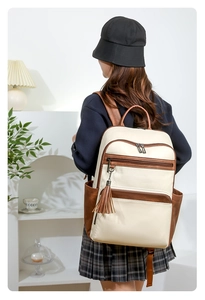 Detail of minimalist beige and brown faux leather backpack with long tassel and side pocket
