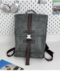 Detail of dark grey PU leather backpack with brown straps and silver metal buckle