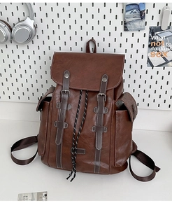 Close-up of vintage brown leather backpack with buckle straps and drawstring closure