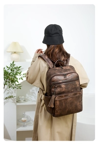 Detail of vintage dark brown backpack with tassel charm and large storage capacity